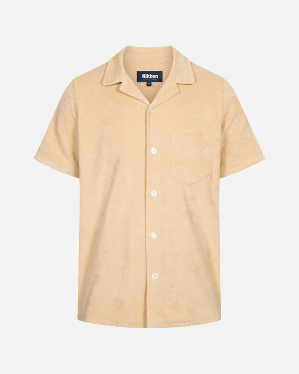 Beige short sleeve shirt with white button closure and one chest pocket