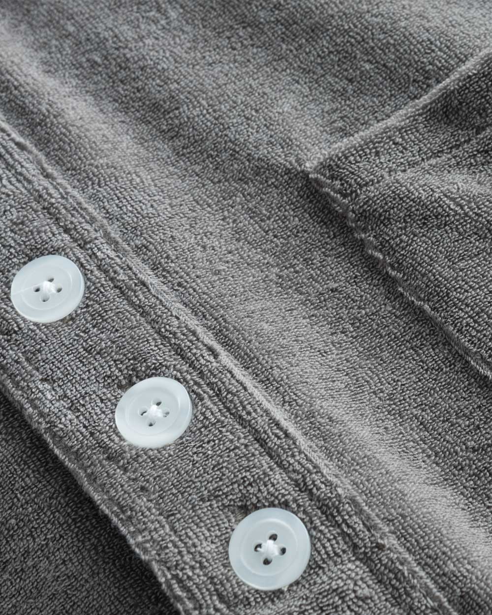 Close up of white buttons on grey shirt