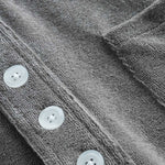 Close up of white buttons on grey shirt