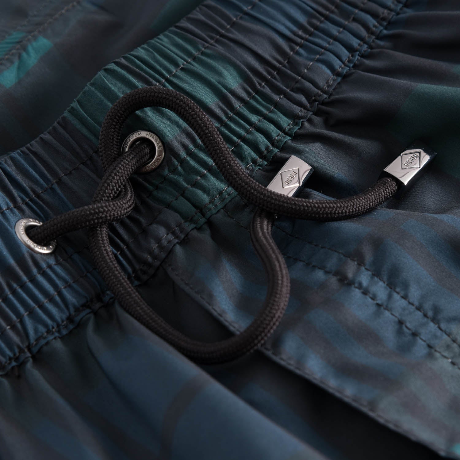 Drawstring waistband on blue-green checked swim trunks