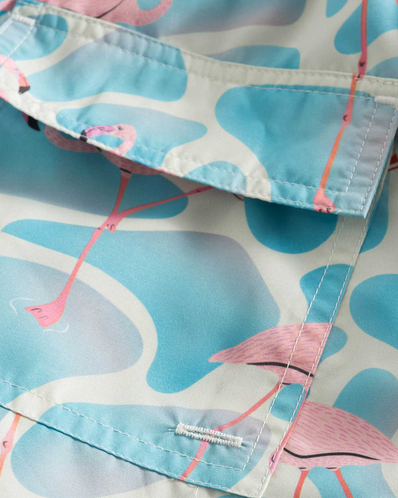 Back pocket on blue swim trunks with pink flamingo print