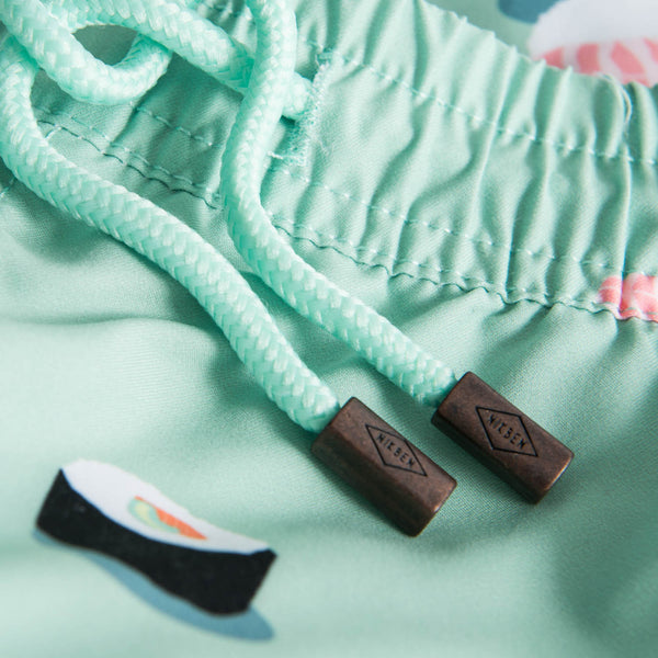 Drawstring waistband on green swim trunks with sushi print