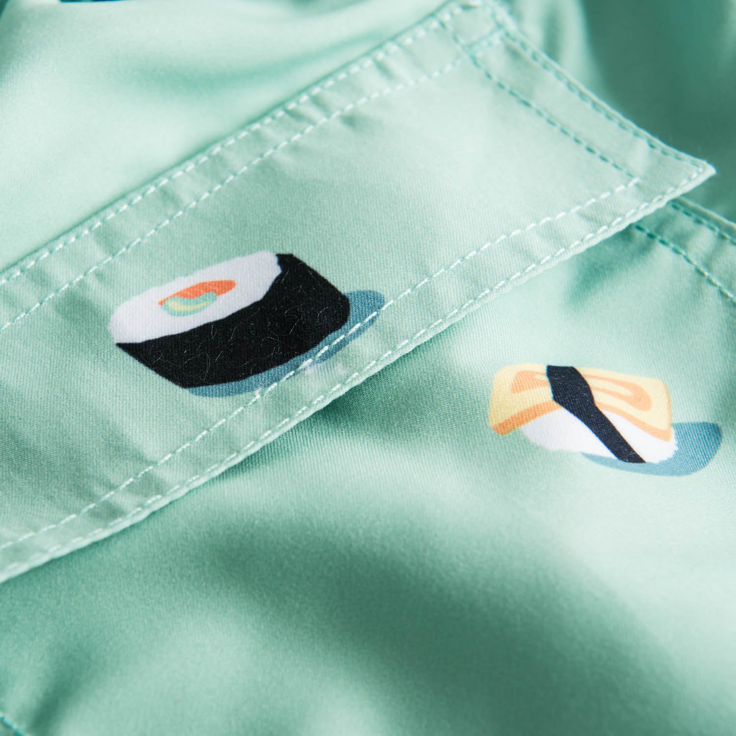 Back pocket on green swim trunks with sushi print