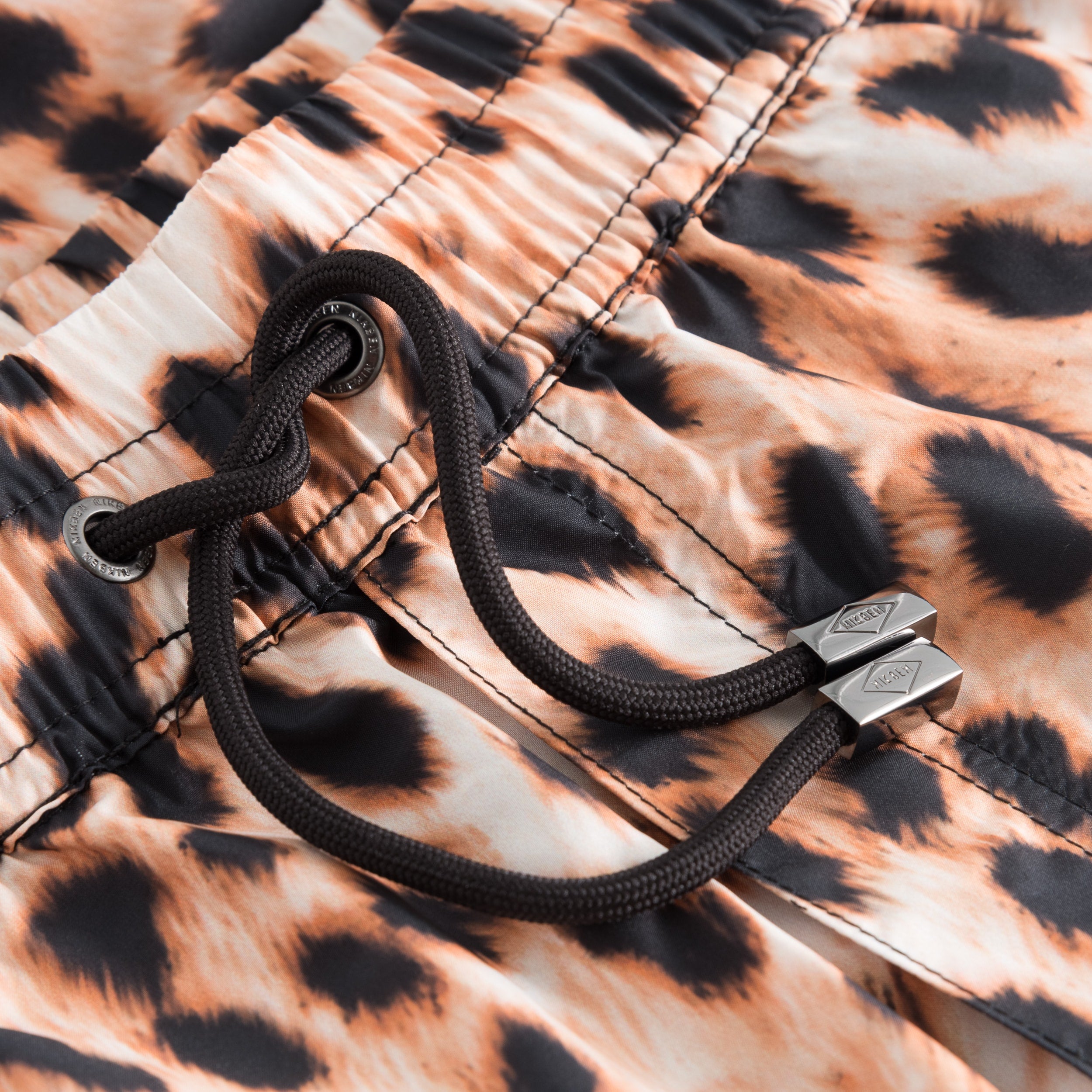 Drawstring waistband on leopard printed swim trunks