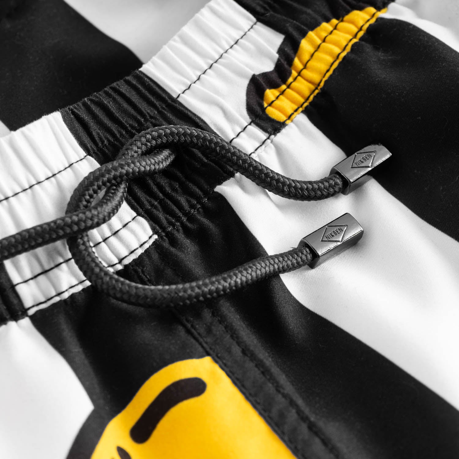Drawstring waistband on black-white swim trunks with lemons