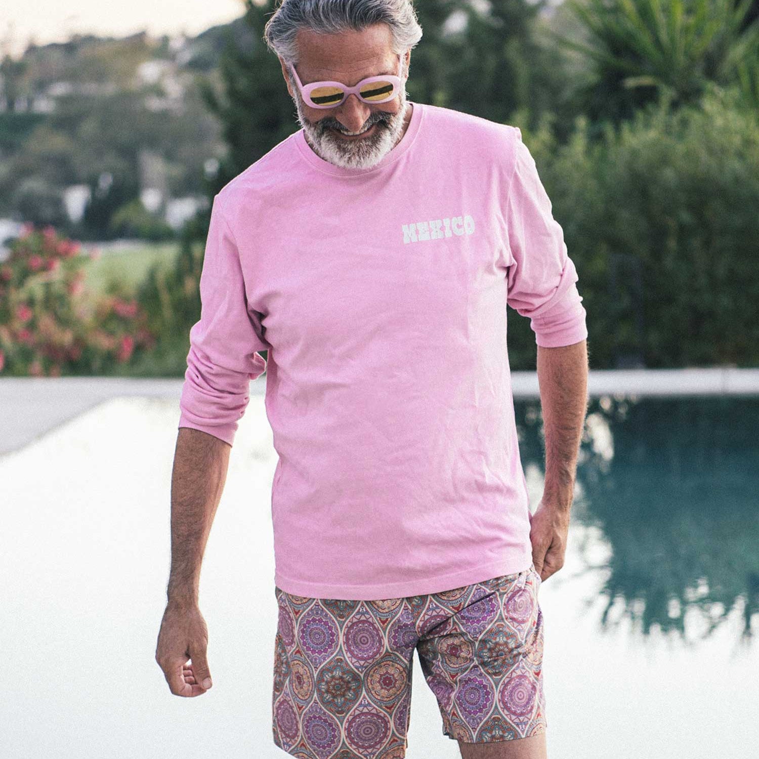 Man with pink shirt and multicolored swim trunks
