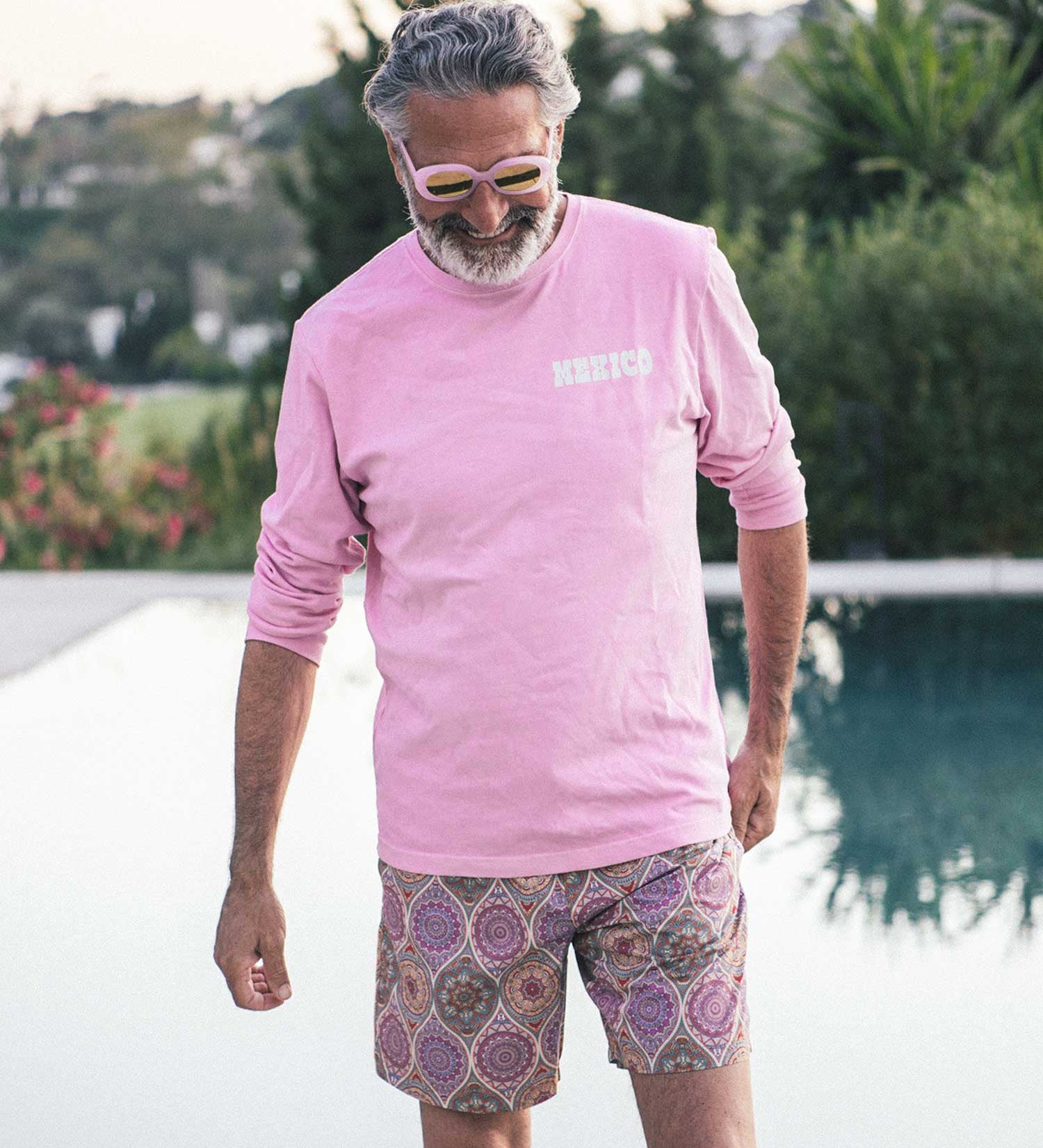 Man with pink shirt and multicolored swim trunks
