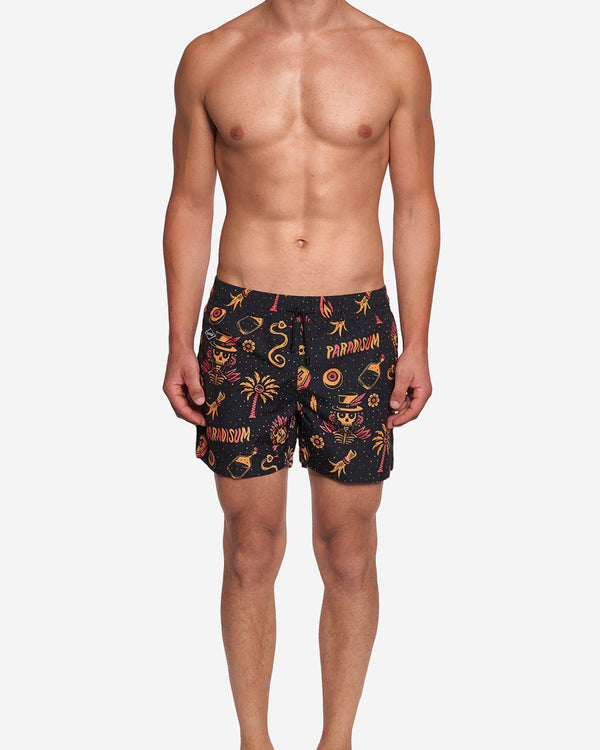 Model wearing black swim trunks with red/yellow print