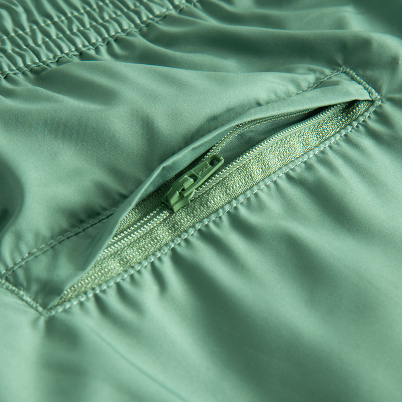 Back zipper pocket on plain green swim trunks