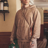 Male model wearing a beige Terry toweling hoodie.