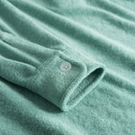 Sleeve with white button on green shirt