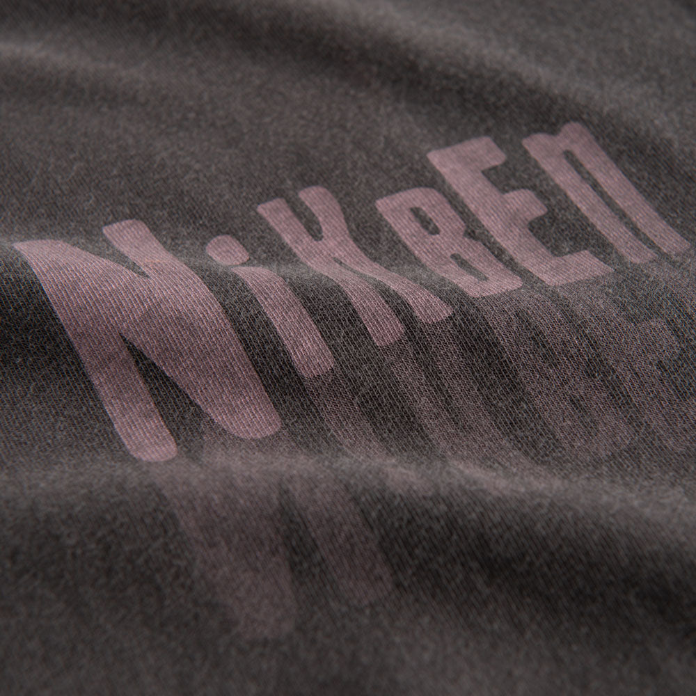 Close up view of pink logo on washed black t-shirt.