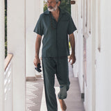 Male model wearing green vacation pants with two front pockets and an elastic drawstring.