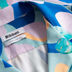 Close up view on open collar on a short-sleeved vacation shirt with a multi-colored graphic patter
