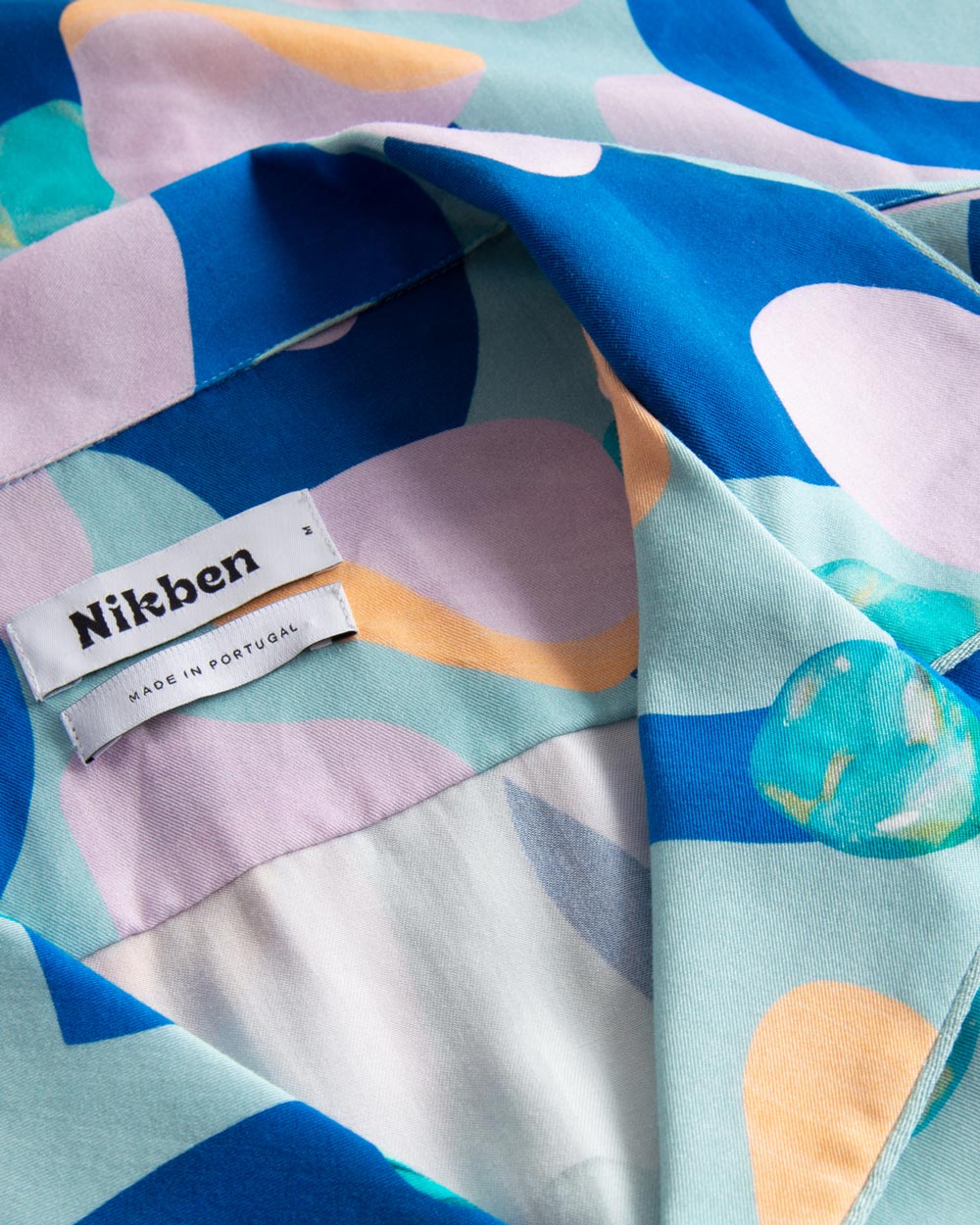 Close up view on open collar on a short-sleeved vacation shirt with a multi-colored graphic patter