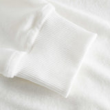 Close-up of ribbed cuffs on a white hoodie.