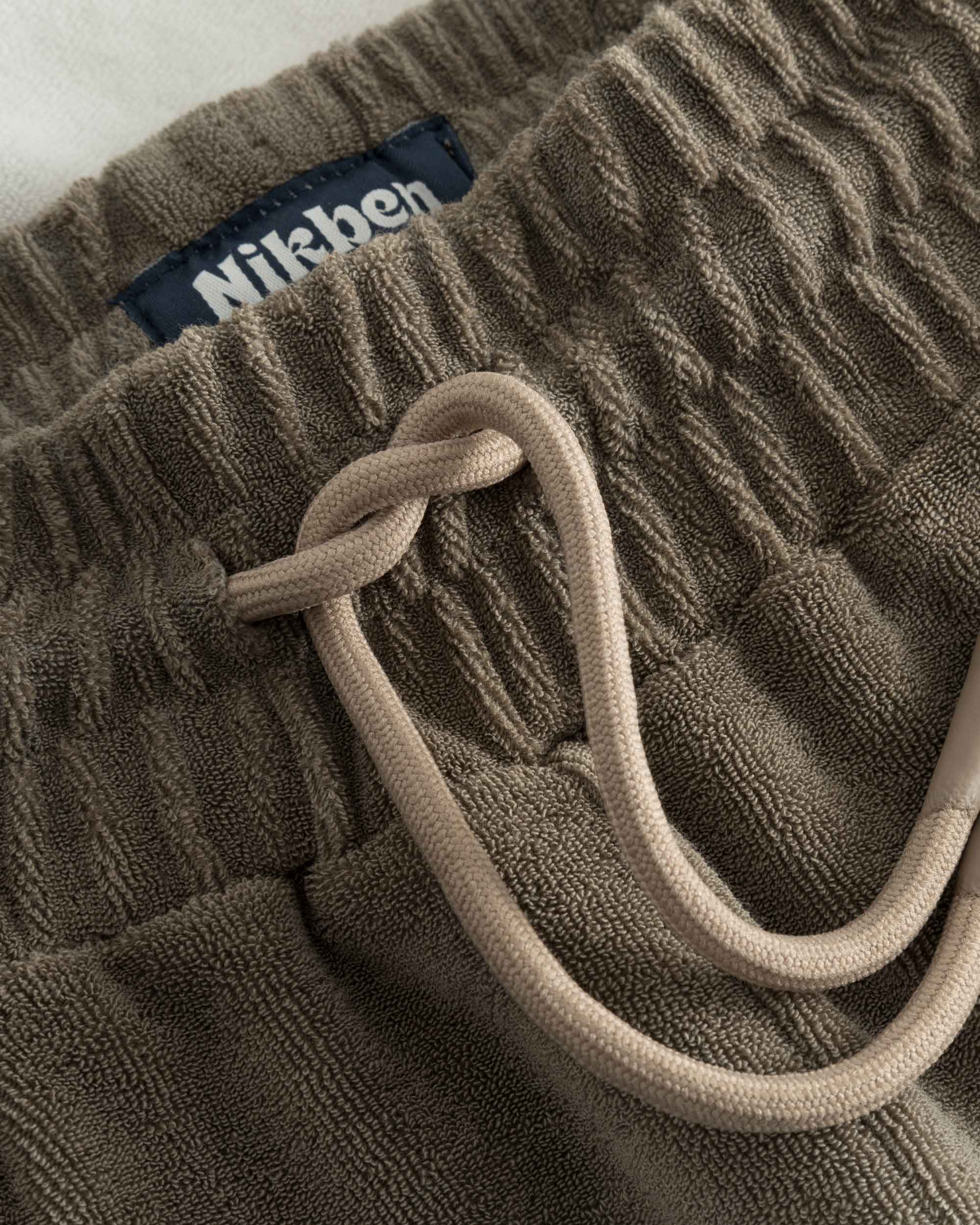 Close up on drawstring on brown and white low cut shorts in terry toweling fabric