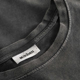 Close-up view of the round neck and stitchings on a washed black t-shirt