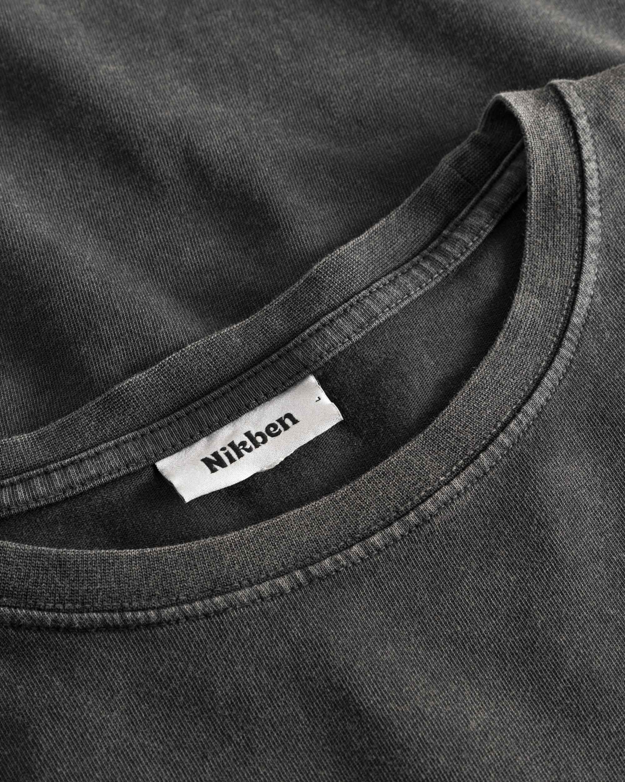Close-up of round neck and stitching on washed black T-shirt
