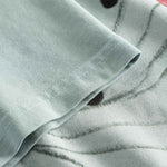 Close-up view of the sleeve and stitchings on a grey t-shirt