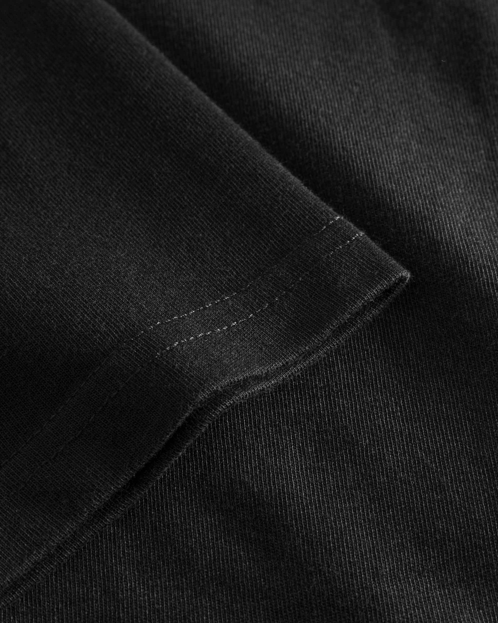 Close-up view of sleeve and stitchings on a black t-shirt