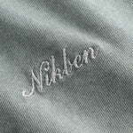Close up of white script logo on grey t-shirt.