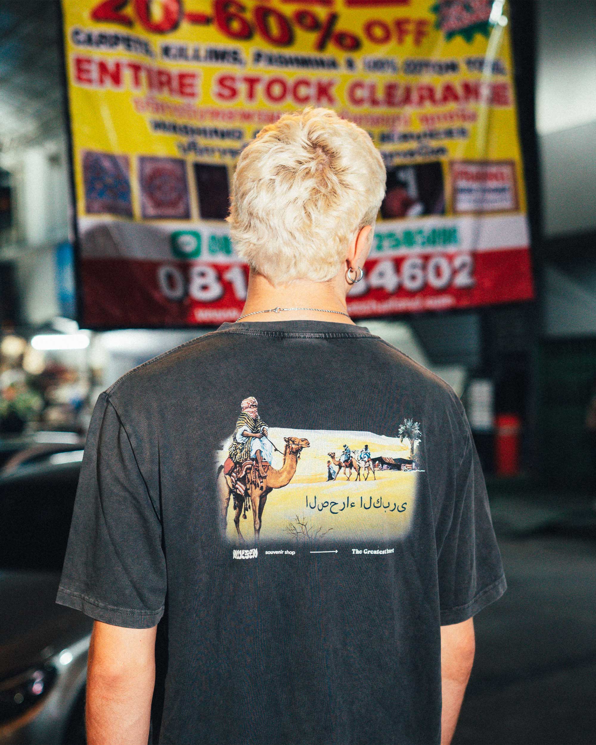 Back view of male model wearing a washed black t-shirt with large back print.