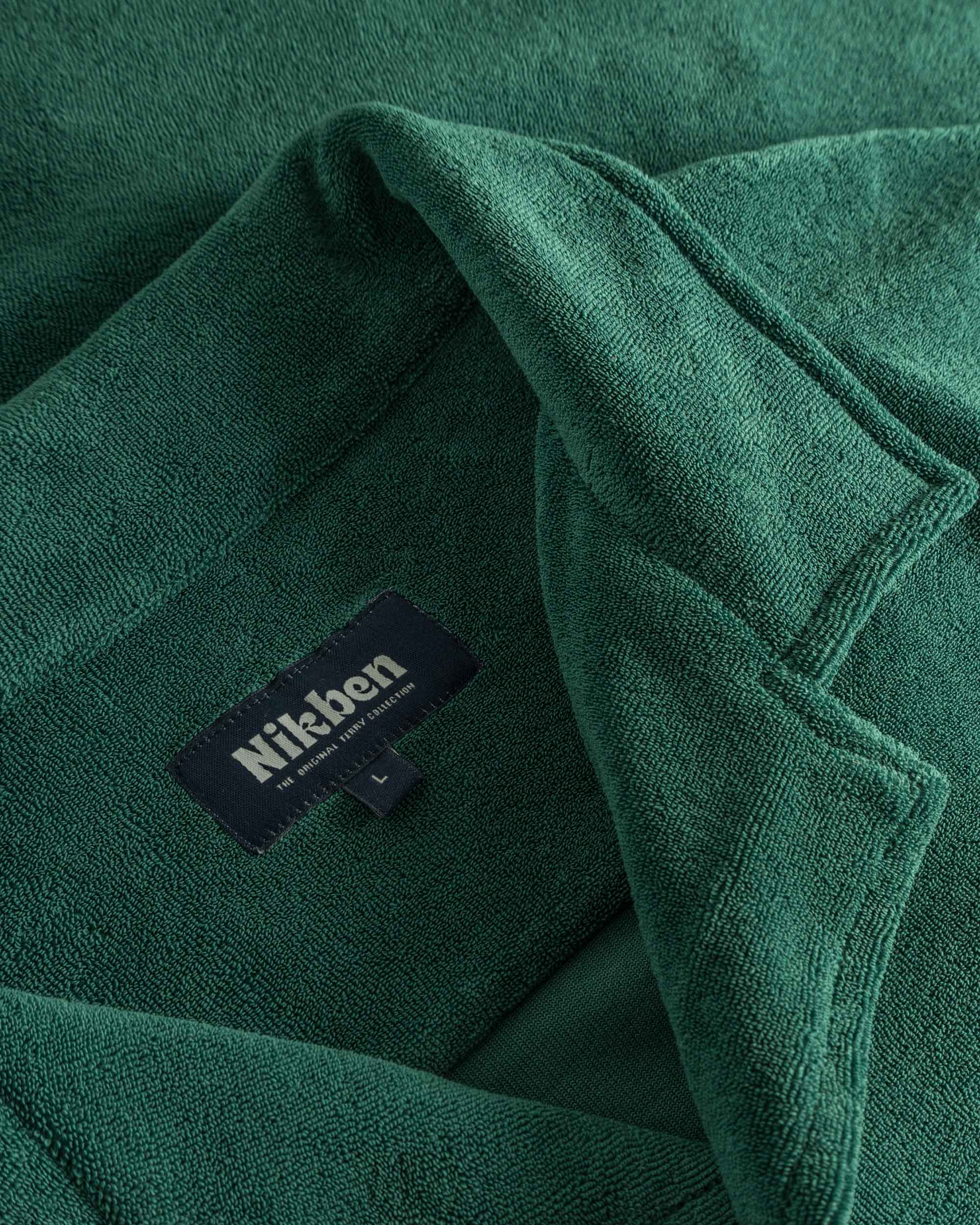 Close up of open collar and tag on a green short sleeve shirt
