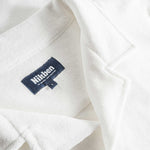 Close up of open collar and tag on an off white short sleeve shirt