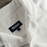 Close up of open collar and tag on a white and brown short sleeve shirt