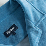 Close up of open collar and tag on a white and sky blue short sleeve shirt