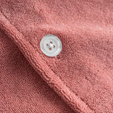 Close up of pearl button on a red/brown short sleeve shirt