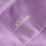 Close up of embroidered logo on a purple, short sleeve, cropped shirt