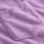 Close up of breast pocket on a purple, short sleeve, cropped shirt