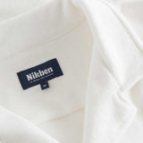 Close up of open collar on a white, short sleeve, cropped shirt 