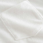 Close up of chest pocket on a white, short sleeve, cropped shirt