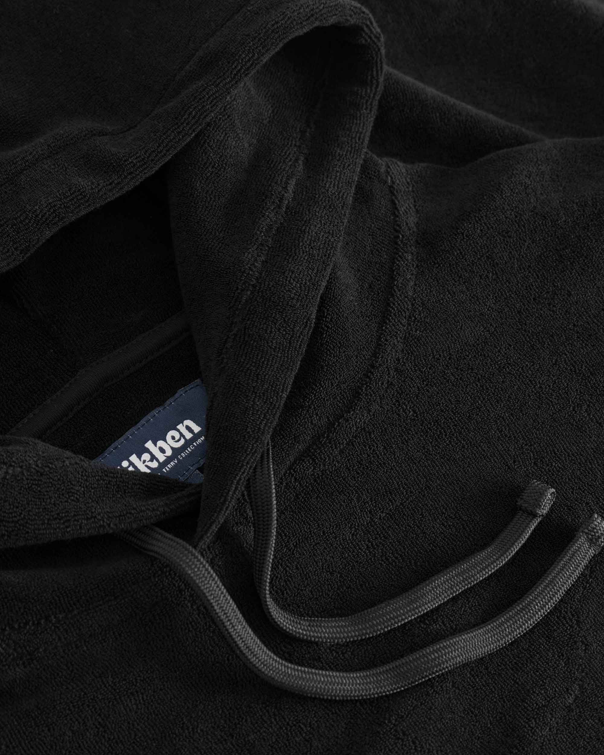 Close up of drawstings on a black hoodie.