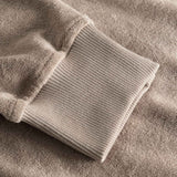 Close-up of ribbed cuffs on a beige hoodie.