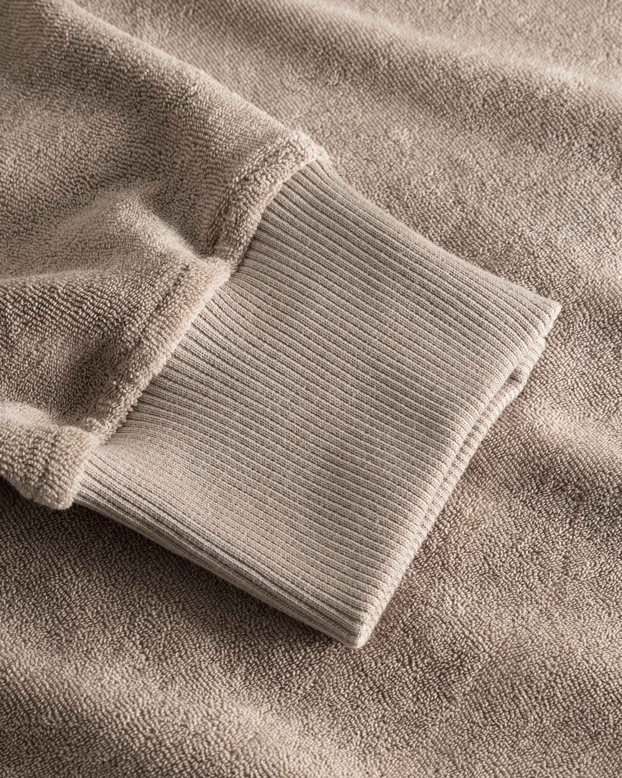 Close-up of ribbed cuffs on a beige hoodie.