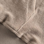 Close-up of stitchings on a beige hoodie.