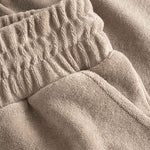 Close up on elastic waistband on light brown low cut shorts in terry toweling fabric