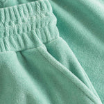 Close up on elastic waistband on grey-green low cut shorts in terry toweling fabric