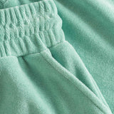 Close up on elastic waistband on grey-green low cut shorts in terry toweling fabric