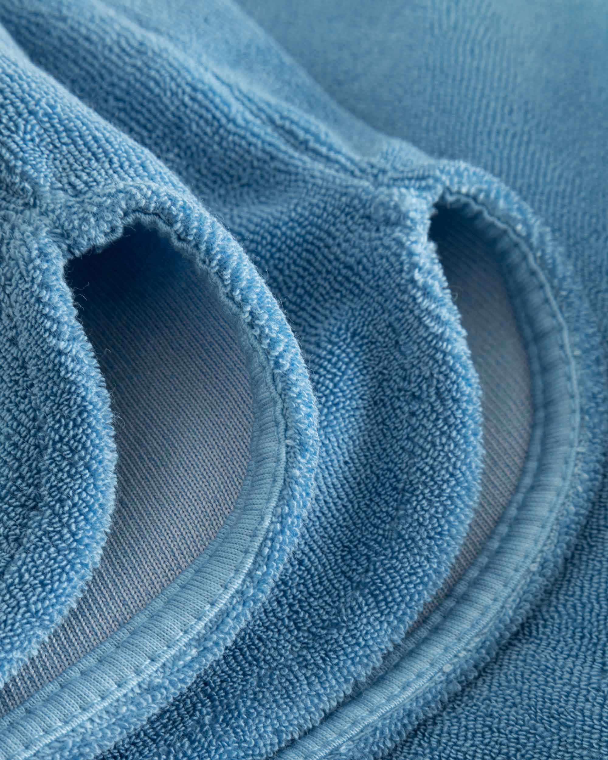 Close up on leg on white and sky blue low cut shorts in terry toweling fabric