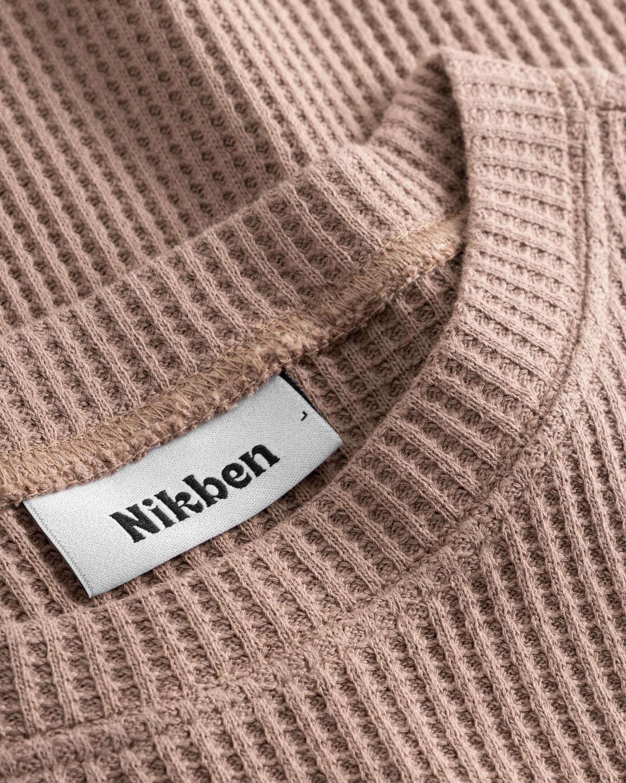 Close up on round neck on a brown waffle-patterned sweatshirt