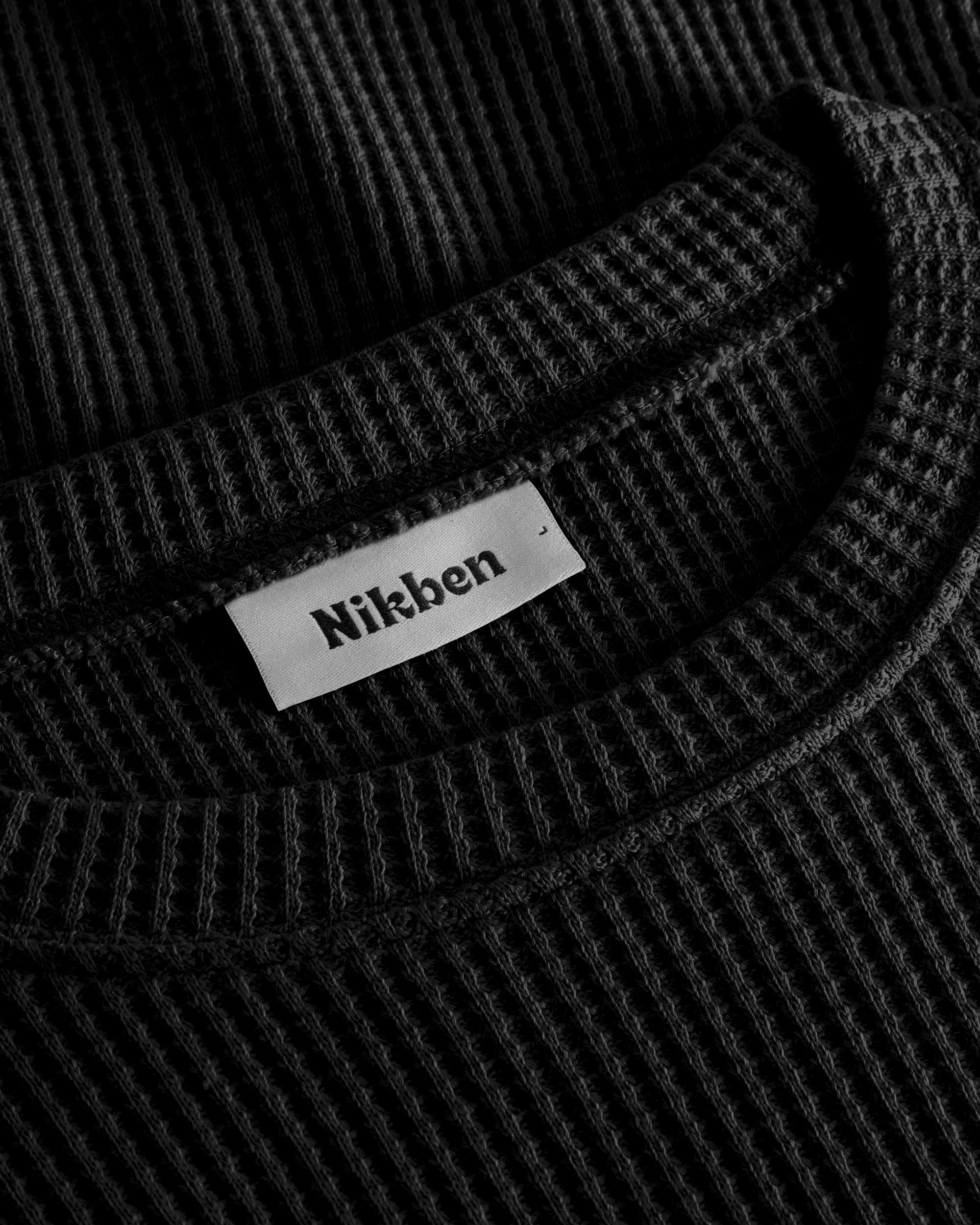 Close up on round neck on a black waffle-patterned sweatshirt