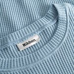 Close up on round neck on a sky blue waffle-patterned sweatshirt