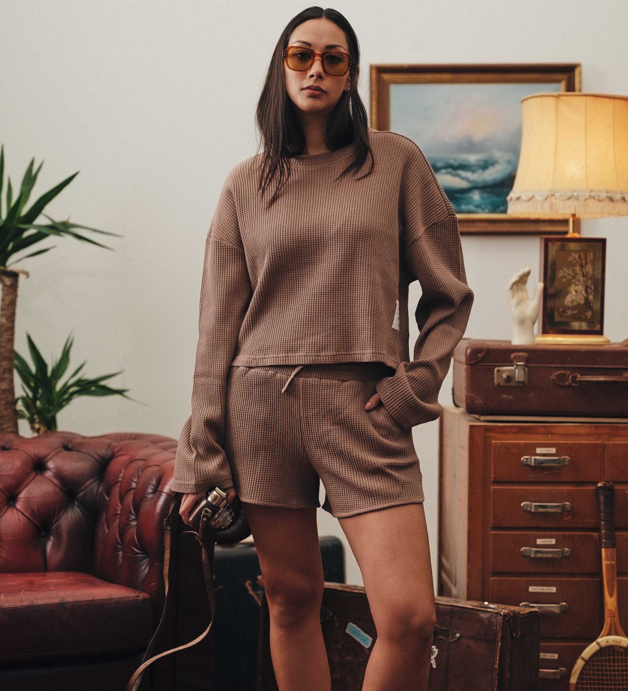 Female model wearing a brown waffle-patterned cropped sweatshirt with a stitched-on material label.