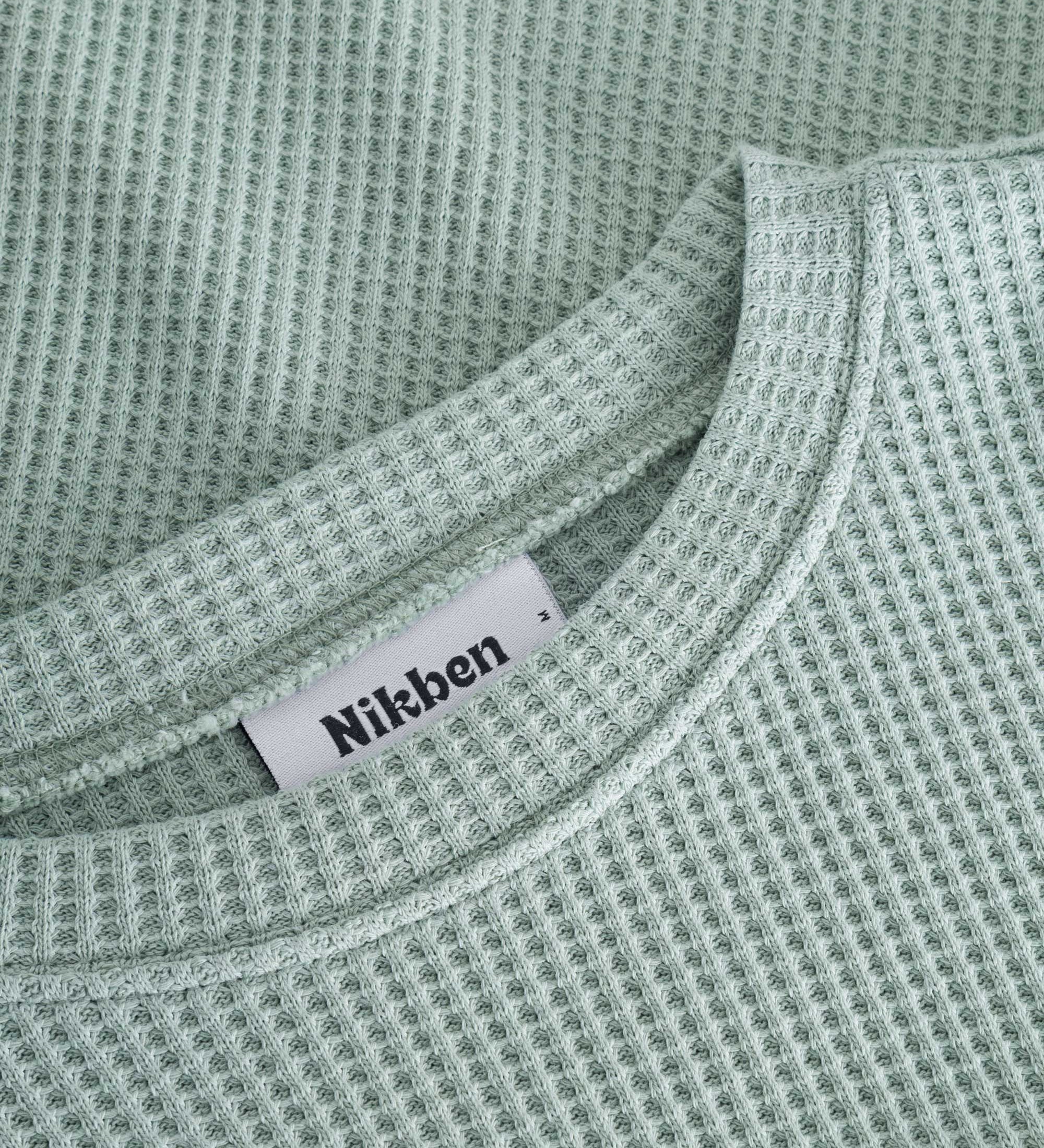 Close up on round neck on a mint green waffle-patterned cropped sweatshirt
