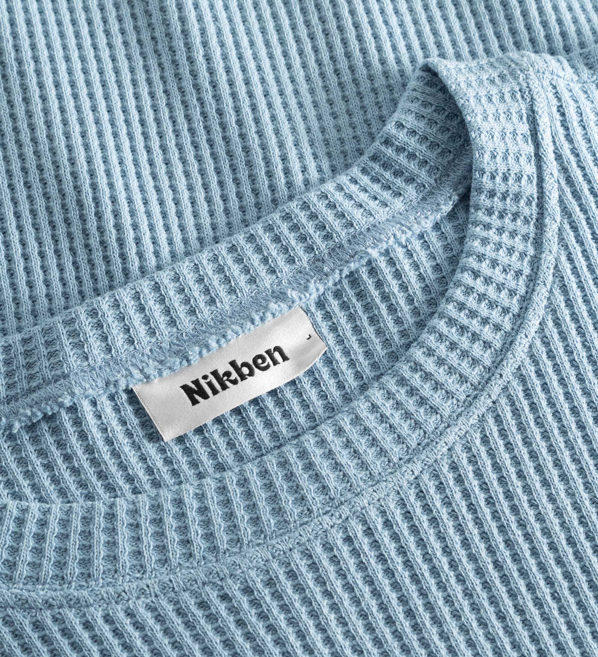 Close up on round neck on a sky blue waffle-patterned cropped sweatshirt